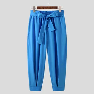 Front view of stylish blue men's cropped casual pants with a decorative bow-knot belt