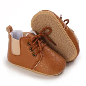 Primer plano de zapatos de bebé marrón con suela antideslizante y textura de cuero suave.