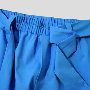Close-up detail of blue men's casual trousers featuring an elastic waist and matching belt