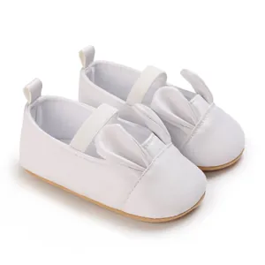 Detailed view of white baby walking shoes featuring soft soles and cute bunny ears