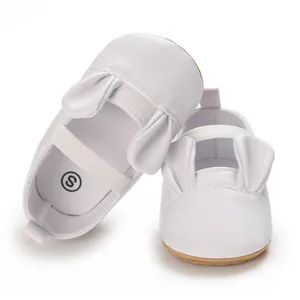Detailed view of white baby walking shoes with cute cartoon bunny ears and soft soles