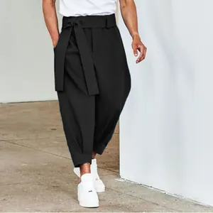 Detailed view of men's black tie-waist cropped casual pants featuring a relaxed fit