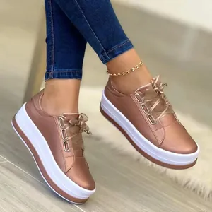 Stylish women's rose gold plateau sneakers with thick white soles and ribbon laces