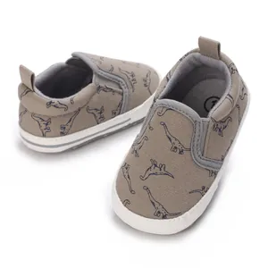 Close-up detail of infant walker shoes featuring a soft sole and dinosaur print