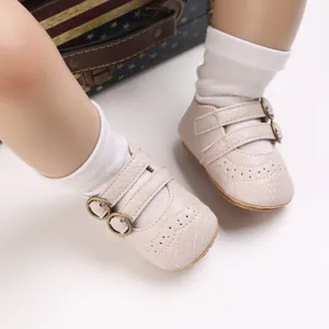 Close-up of beige soft-sole baby princess shoes with buckle straps and wingtip detail