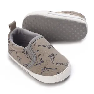Detailed view of infant walking shoes showing non-slip soft sole and dinosaur print