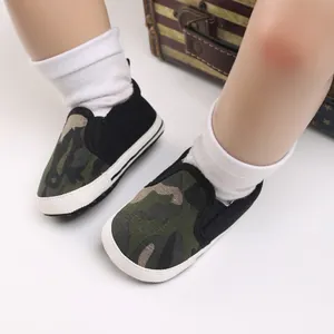 Detailopname van camouflage babyschoentjes met zachte zolen en witte sokken