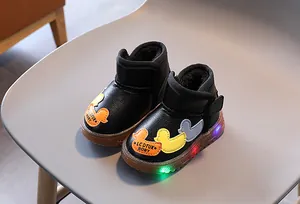 Primer plano de botas de invierno con LED para niños con parches de pato y forro polar