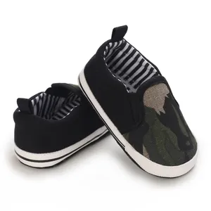 Gedetailleerd overzicht van babyloopschoenen met zachte zool, camouflage en zwart canvas.