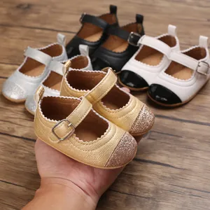 Hand-held close-up of multi-color glitter baby girl walking shoes on wooden floor