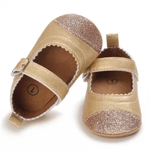 Detail view of gold glitter baby girl pre-walker shoes with scalloped edges and buckle strap