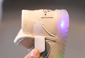 Detalle del cierre de velcro y la suela con luces LED en botas de invierno para niños.