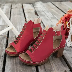 Rote Damen-Römersandalen mit Blockabsatz und Schnürung auf rustikalen Holzbohlen