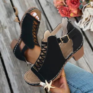 Nahaufnahme von schwarzen Riemchen-Sandalen mit Blockabsatz und eleganter Schnalle