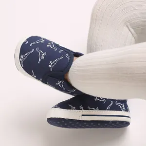 Close-up view of navy blue baby soft sole walking shoes featuring white dinosaur patterns
