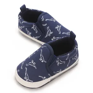 Detail view of navy blue soft-sole baby walker shoes featuring cute white dinosaur prints