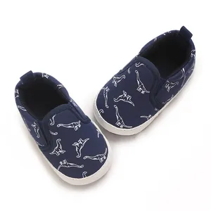 Navy blue baby walking shoes with white dinosaur print and soft white soles