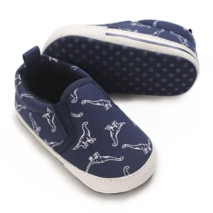 Detail view of navy baby walking shoes with white dinosaur pattern and non-slip sole
