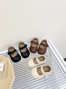 Three pairs of toddler Mary Jane shoes in black, brown, and beige displayed on a shelf.