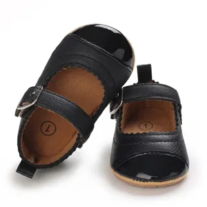 Detailed macro view of black patent leather baby Mary Jane shoes with soft rubber soles and buckles