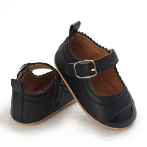 Detailed view of black baby girl Mary Jane shoes with buckle strap and scalloped trim