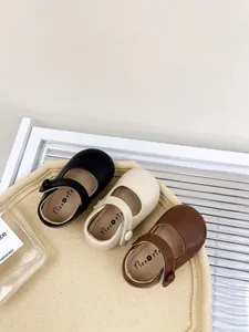 Detail view of three pairs of toddler Mary Jane shoes in black, beige, and brown