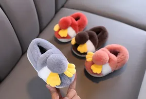 Dettaglio di graziose pantofole di peluche per bambini con design a uccello dei cartoni.