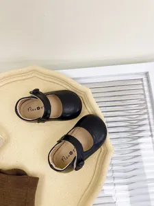 Detailed top-down view of black soft-sole baby Mary Jane shoes on a tray