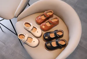 Detail shot of girls Mary Jane shoes with heart cutout in white, brown and black