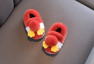 Primo piano di graziose pantofole di peluche rosse per bambini con dettagli di ali.