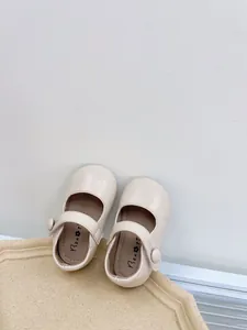 Close-up view of soft-soled baby Mary Jane shoes in cream white leather