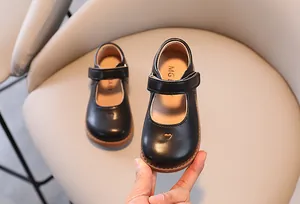 Detail view of black girls' Mary Jane shoes with heart cutout and velcro strap