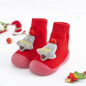 Gros plan de chaussettes de Noël rouges pour bébé avec grelots en peluche