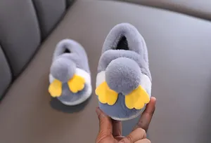Primo piano di graziose pantofole a pinguino in peluche grigio per bambini con morbida pelliccia