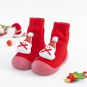 Gros plan de chaussures bébé rouges festives avec bonhomme de neige 3D et semelles roses
