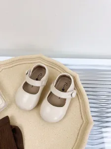 Detail view of cream baby Mary Jane shoes with soft sole and hook-loop strap.