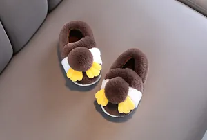 Dettaglio di simpatiche pantofole di peluche marroni per bambini con texture soffice