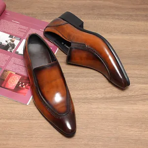 Detailansicht handpolierter brauner Lederschuhe mit spitzer Kappe und Brogue-Details