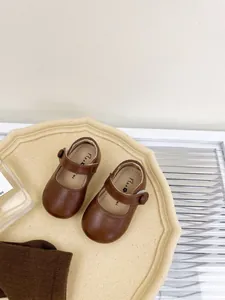 Detailed view of brown soft-sole baby Mary Jane leather toddler shoes on tray