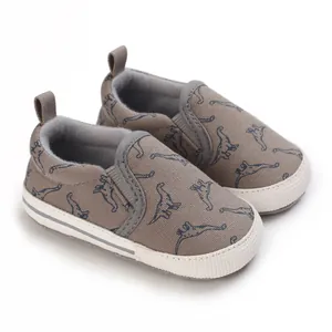 Detailweergave van grijze baby canvas schoenen met dinosaurusprint en zachte zool
