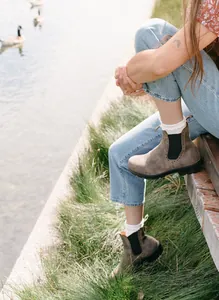 Botines Chelsea de cuero marrón con detalles brogue en un entorno junto al lago