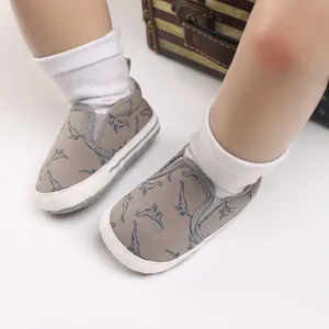 Detailopname van baby canvas schoenen met dinosaurusprints en zachte witte zolen