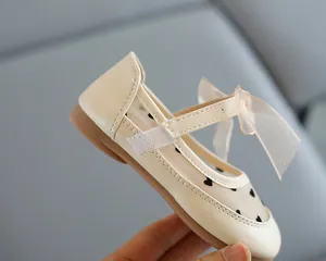 Nahaufnahme von beigen Mädchen-Prinzessinenschuhen mit atmungsaktivem Mesh und Schleife