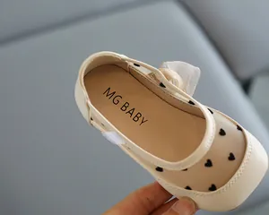 Nahaufnahme von atmungsaktiven Prinzessinnenschuhen für Mädchen mit Herzmuster und Schleife