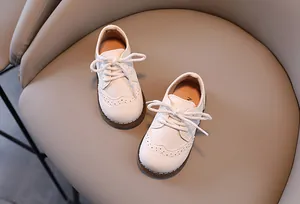 Detailansicht der weißen Kinderschuhe aus Leder im britischen Stil mit Schnürung