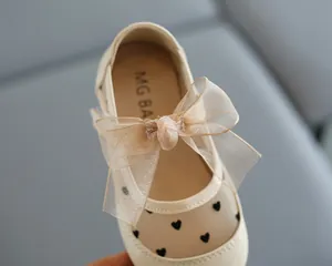 Nahaufnahme von Mädchen-Prinzessin-Schuhen mit atmungsaktivem Netz und Schleifenverzierung.
