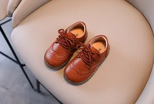Detailansicht brauner Lederschuhe für Jungen im britischen Brogue-Stil mit Schnürung.