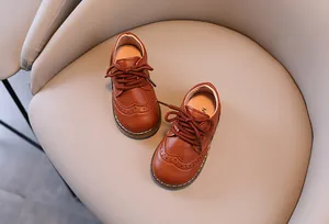 Detailansicht brauner Kinderschuhe aus Leder im britischen Stil mit Brogue-Mustern