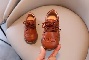 Detailansicht der braunen Lederschuhe im britischen Stil für Jungen mit Budapester Muster