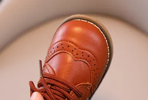 Nahaufnahme von braunen Lederschuhen für Jungen mit klassischen Budapester Details